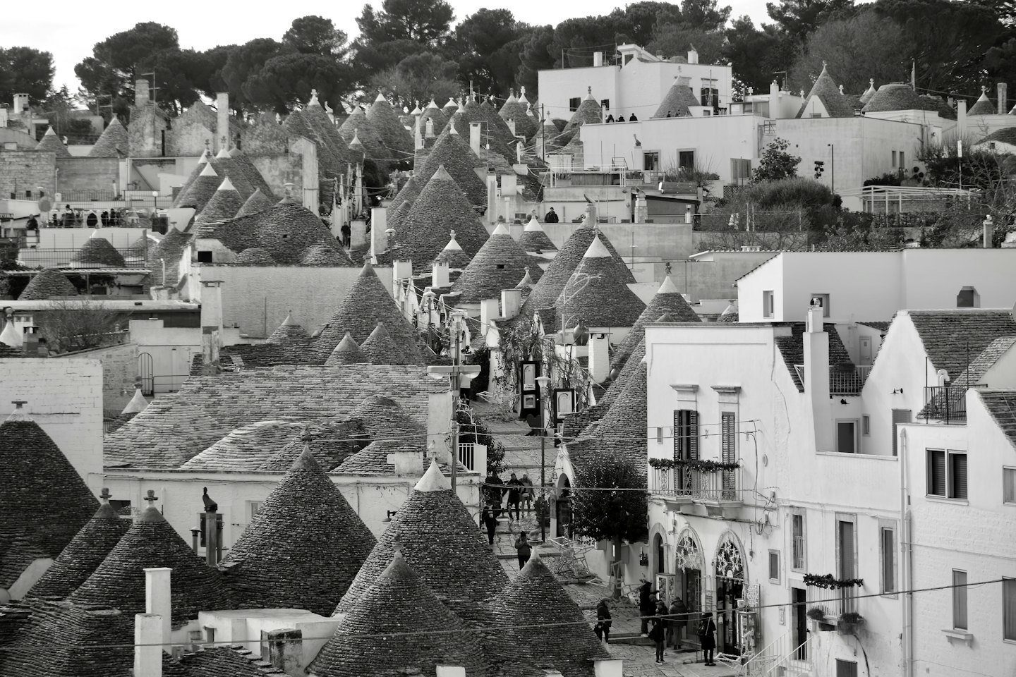 Case trullo tradizionali con tetti conici su una collina storica.